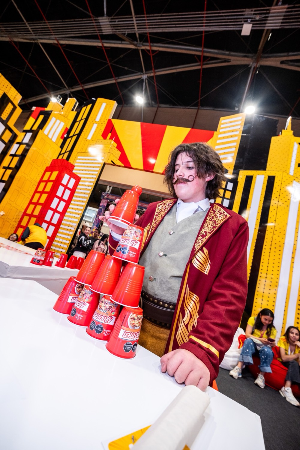 Personaje en vivo apilando vasos de Ajinomen en el reto del stand
