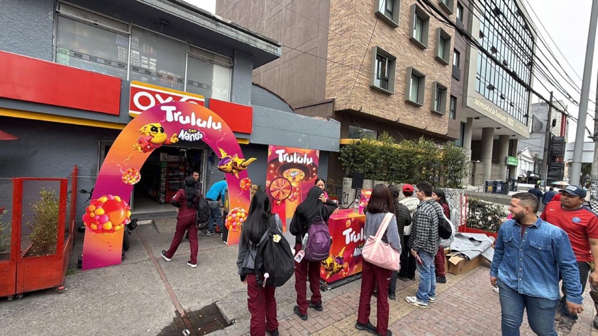 Arco inflable de Trululu en la entrada de una tienda OXXO con consumidores haciendo fila en la acera